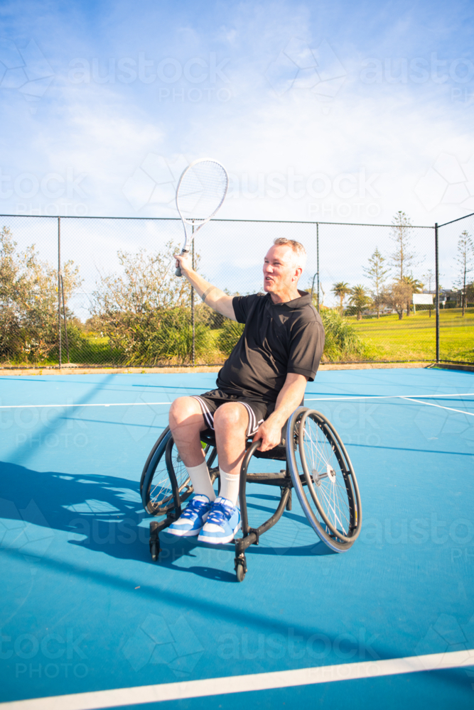 man in wheelchair on tennis court - Australian Stock Image