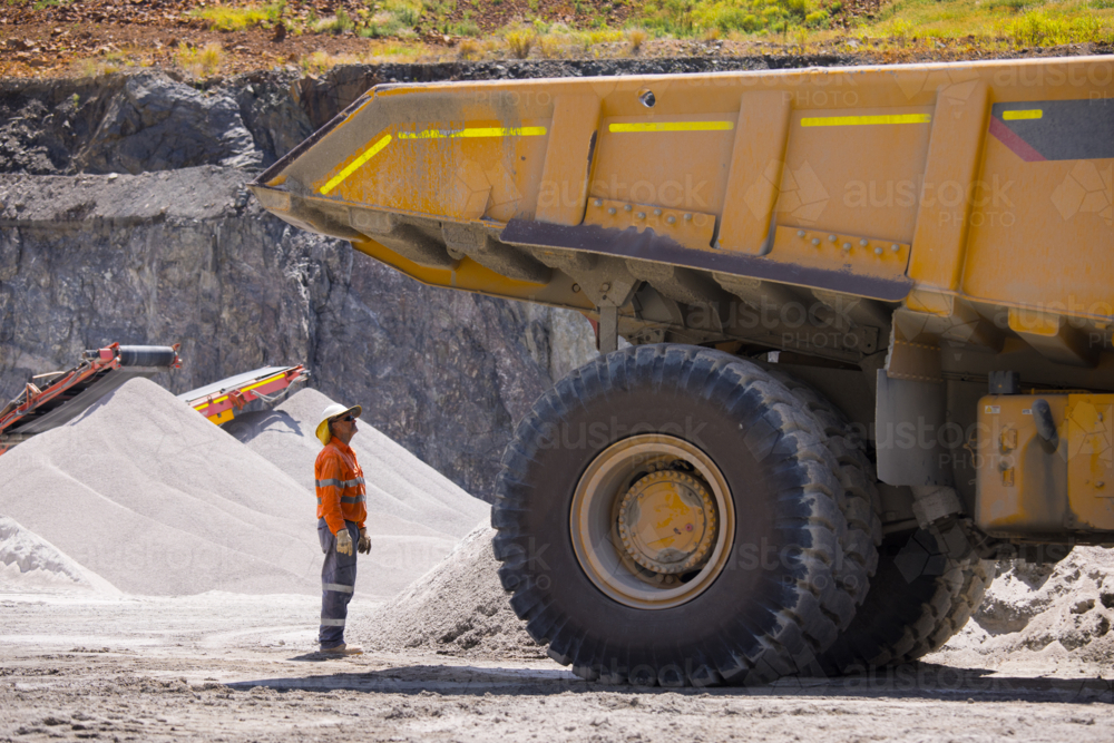 Man in workwear checking the back end of the hauler truck. - Australian Stock Image