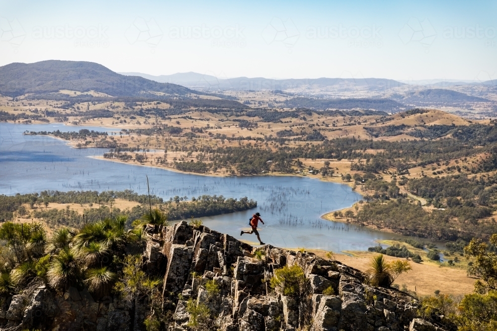 Man jumping on mountain ridge - Australian Stock Image