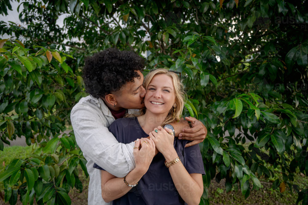 Man kisses girlfriend, young happy and in love couple - Australian Stock Image