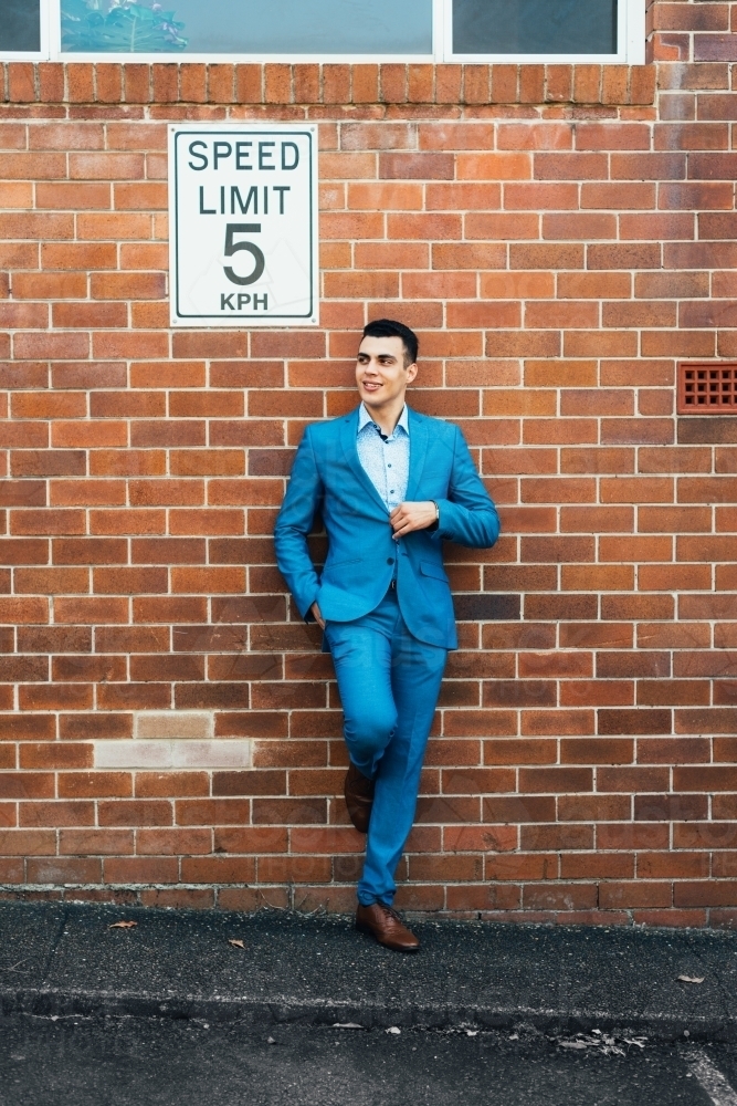 man leaning against wall with speed limit - Australian Stock Image