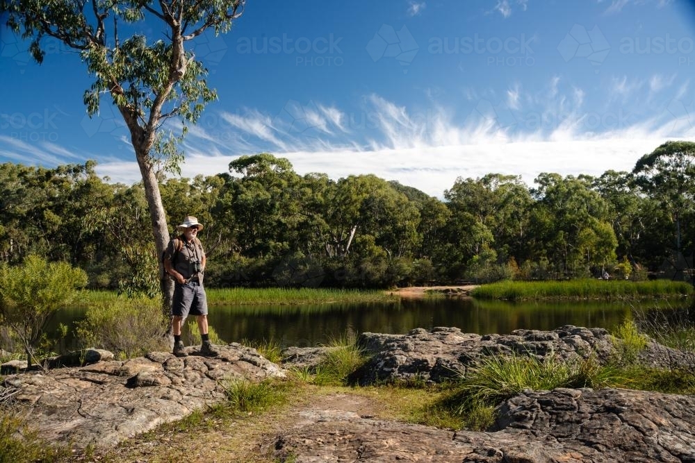 Man looking out at scenic waterway - Australian Stock Image
