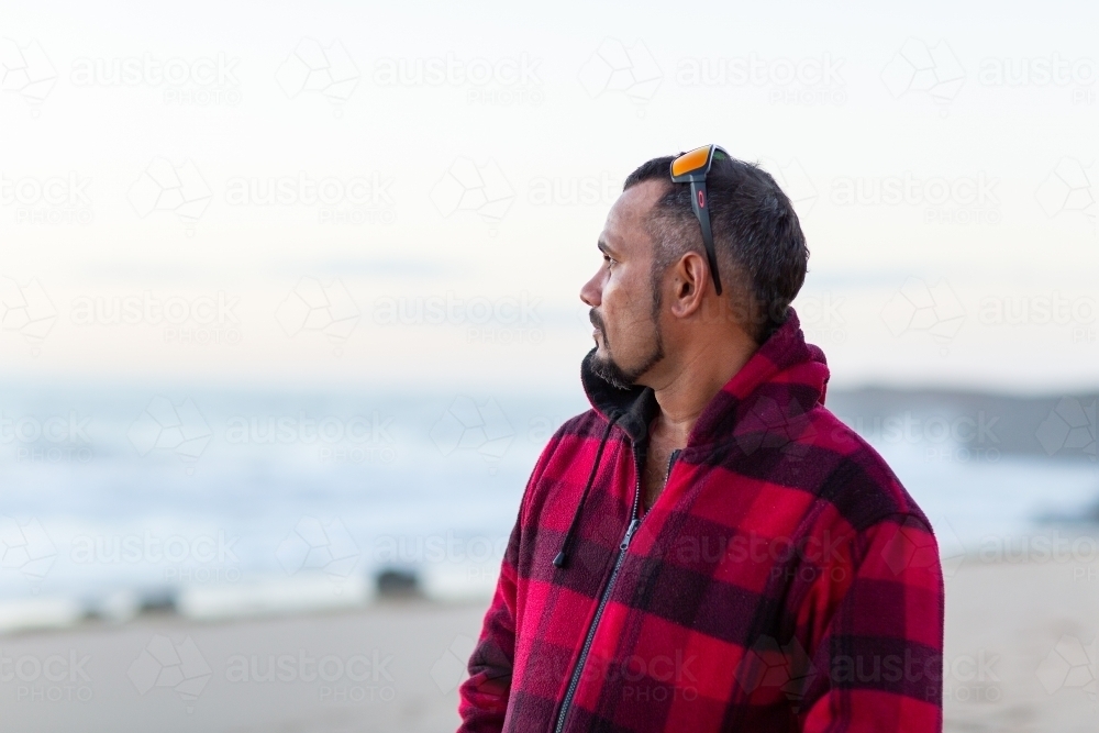 Man looking out to sea at dusk - Australian Stock Image
