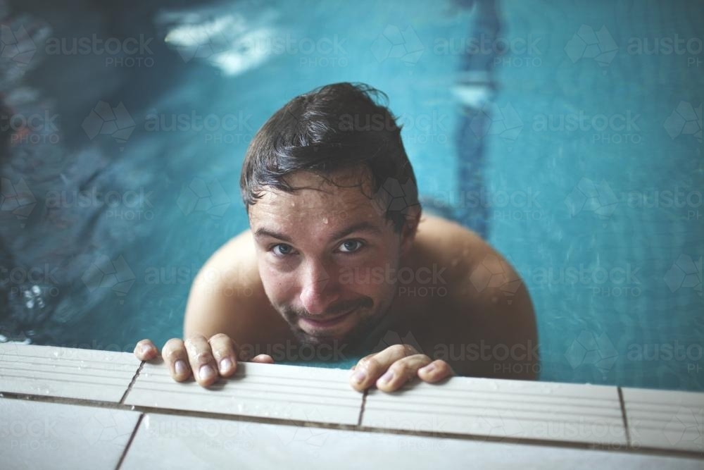 Man Looking up from Contemporary Indoor Lap Pool - Australian Stock Image