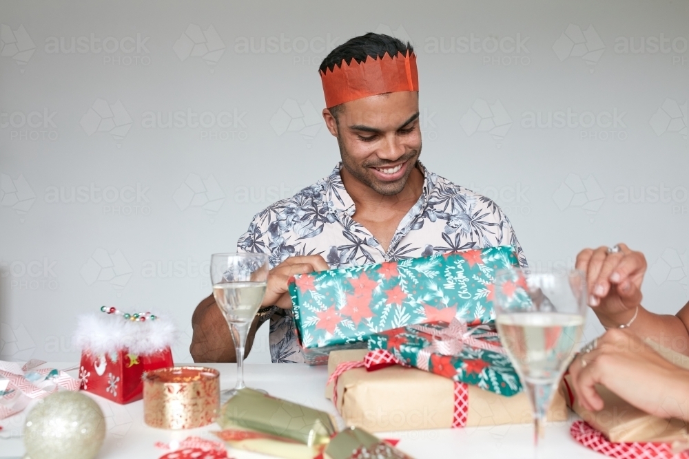 Man opening present at Christmas - Australian Stock Image