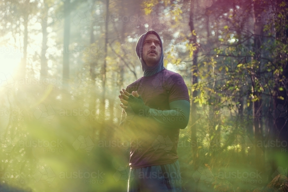 Man pausing in bushland on Morning Run in Fog and Sunshine - Australian Stock Image