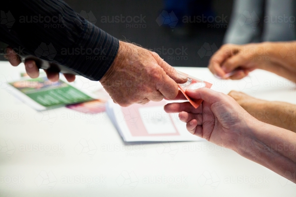 Image of Man paying for entrance with twenty dollar note in cash ...