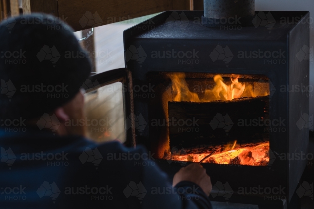 Man poking fireplace - Australian Stock Image