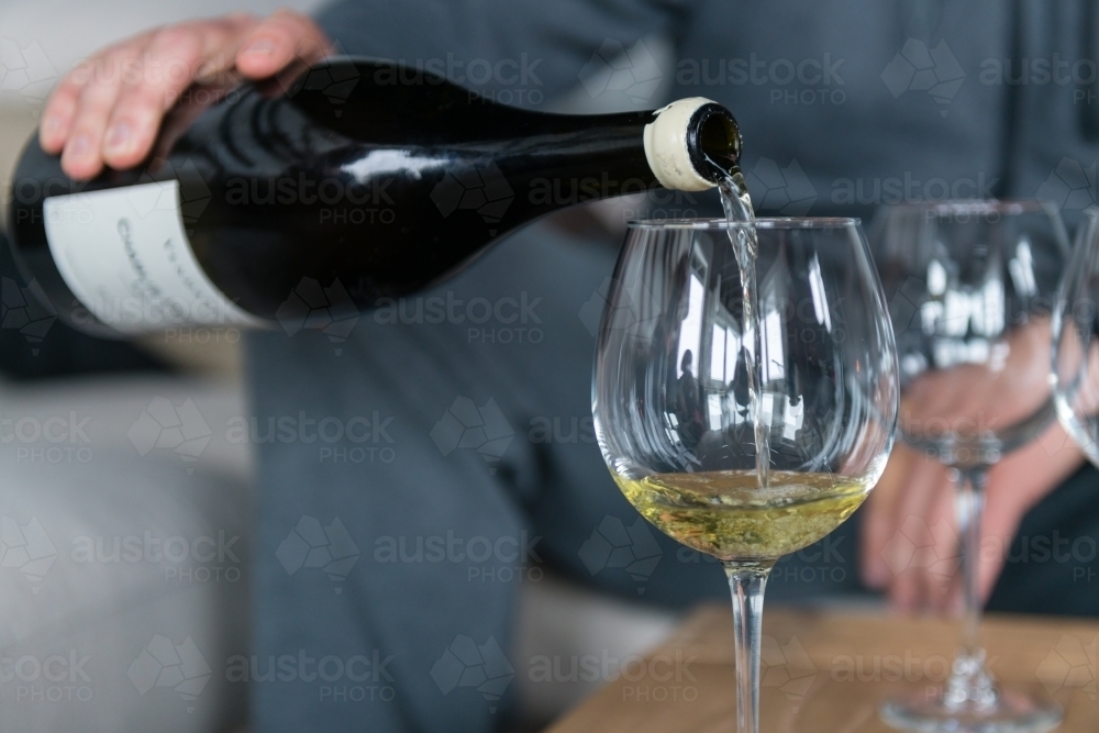 man pouring white wine - Australian Stock Image