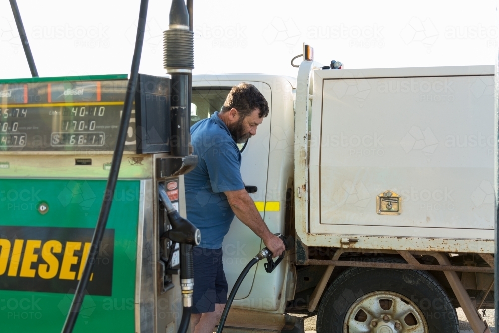 Man putting fuel in ute from diesel bowser - Australian Stock Image
