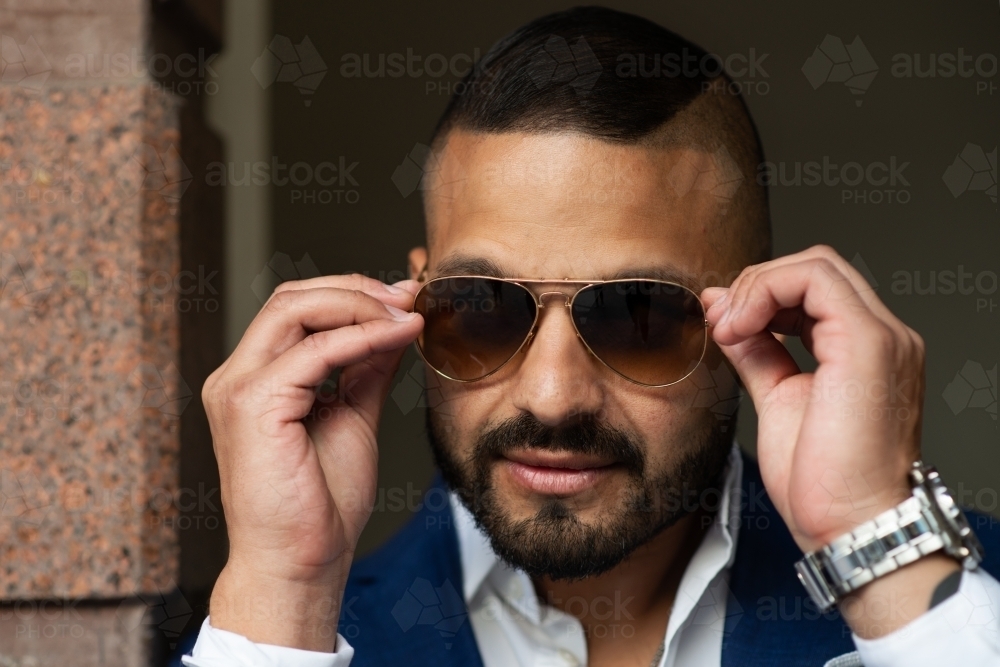 man putting on sunglasses - Australian Stock Image