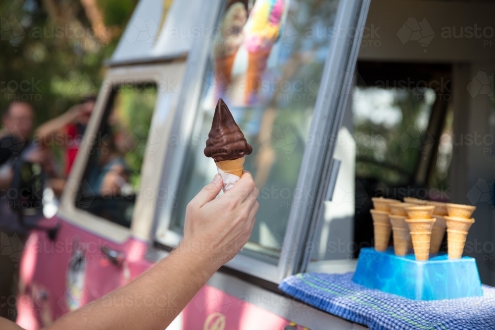 Man receiving chocolate ice cream from ice cream truck - Australian Stock Image