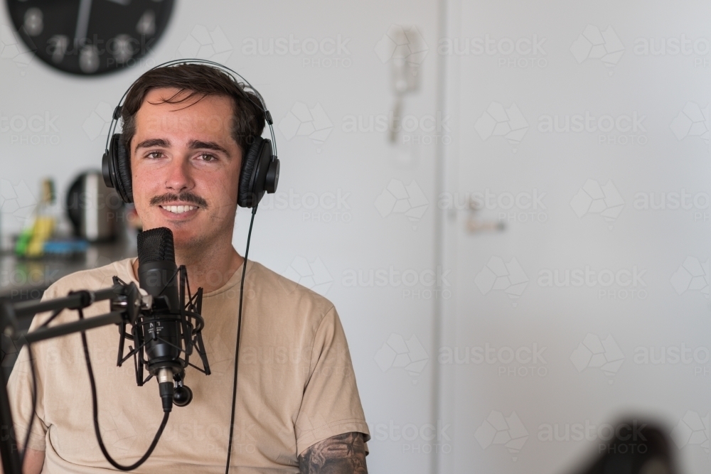 man recording a podcast at home - Australian Stock Image