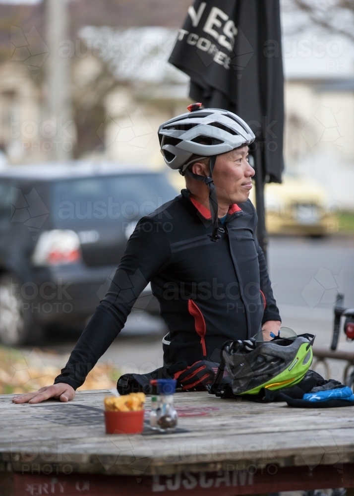 Man relaxing at a cafe after a bike ride - Australian Stock Image