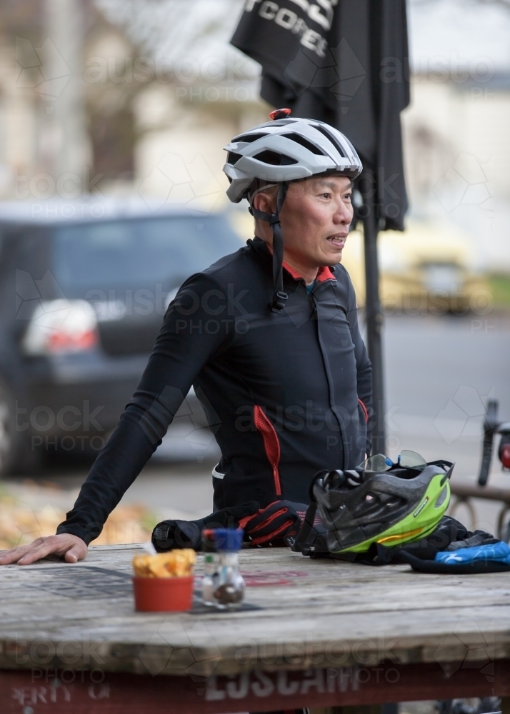 Man relaxing at a cafe after a bike ride - Australian Stock Image