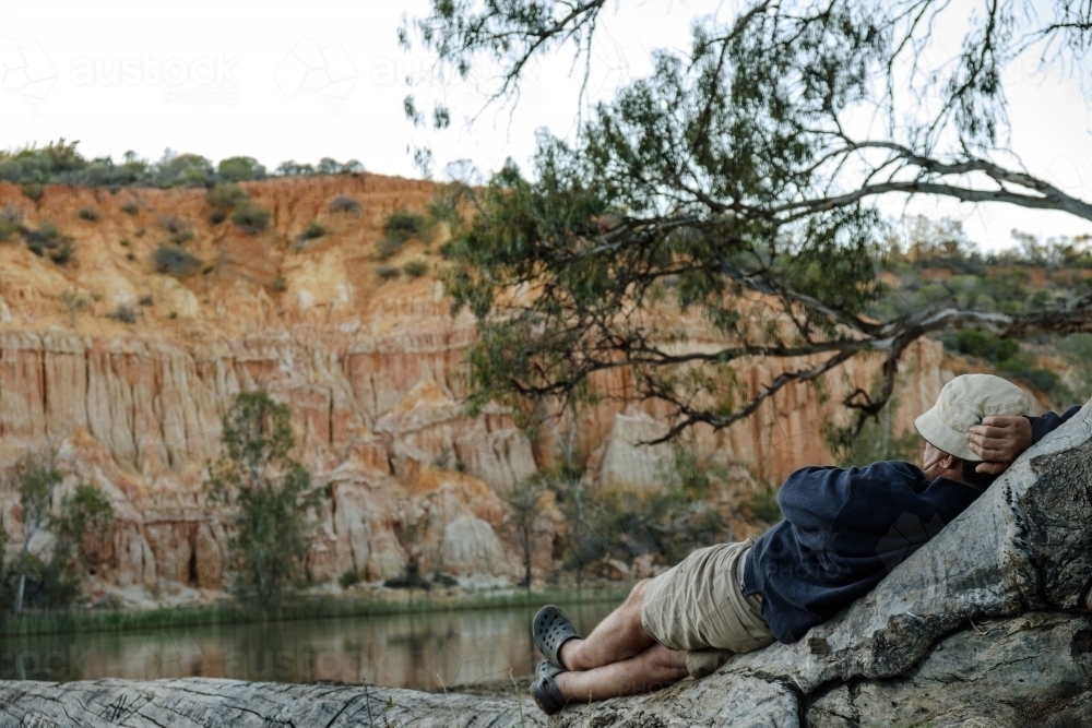 Man relaxing  by the River Murray watching the River boats go by - Australian Stock Image