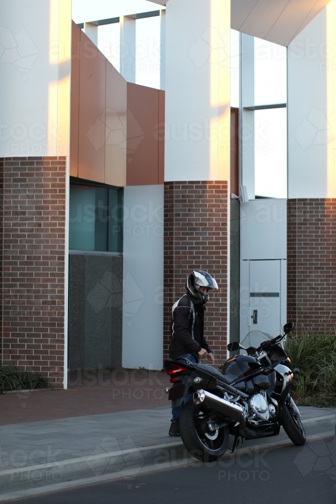 Man riding motorbike on a suburban street - Australian Stock Image