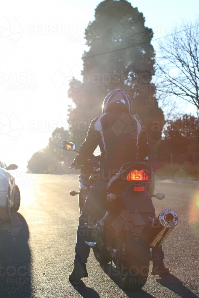 Man riding motorbike on a suburban street - Australian Stock Image