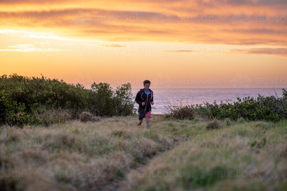 Man Running Away from Beach at Sunrise - Australian Stock Image