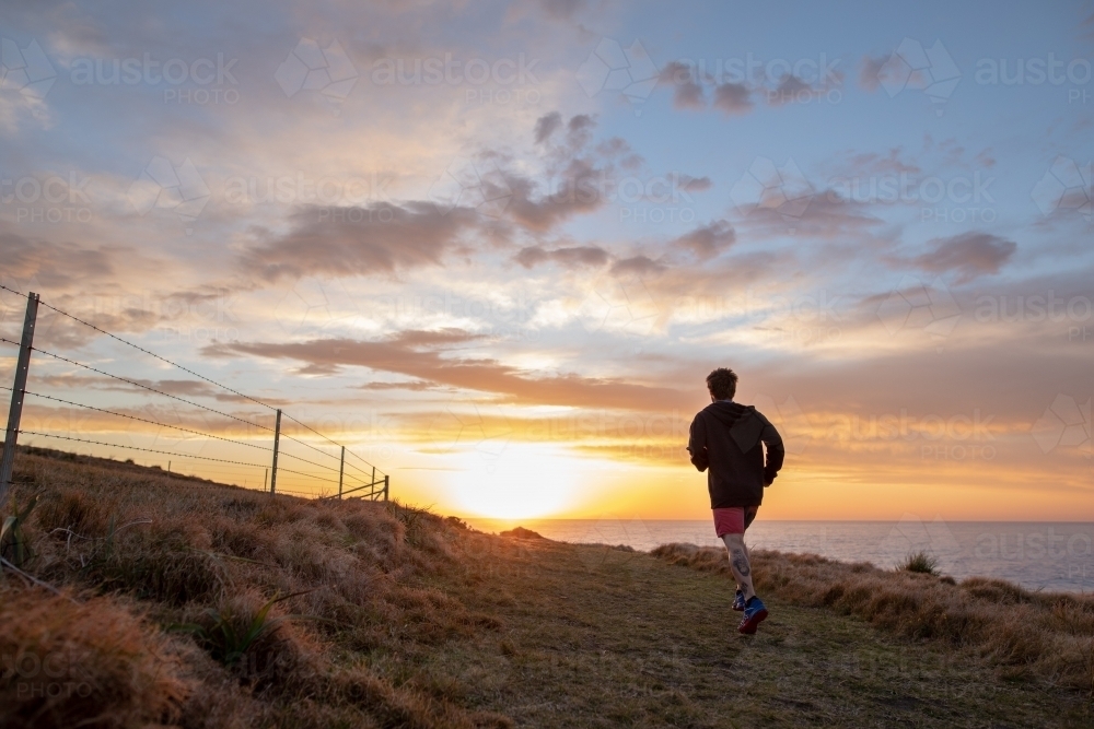 Man Running by The Sea towards Sunrise - Australian Stock Image