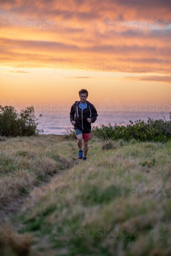 Man Running in Nature Under Pastel Sky - Australian Stock Image