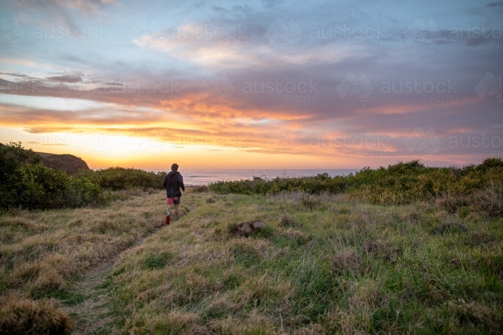 Man Running Towards Beach at Sunrise - Australian Stock Image