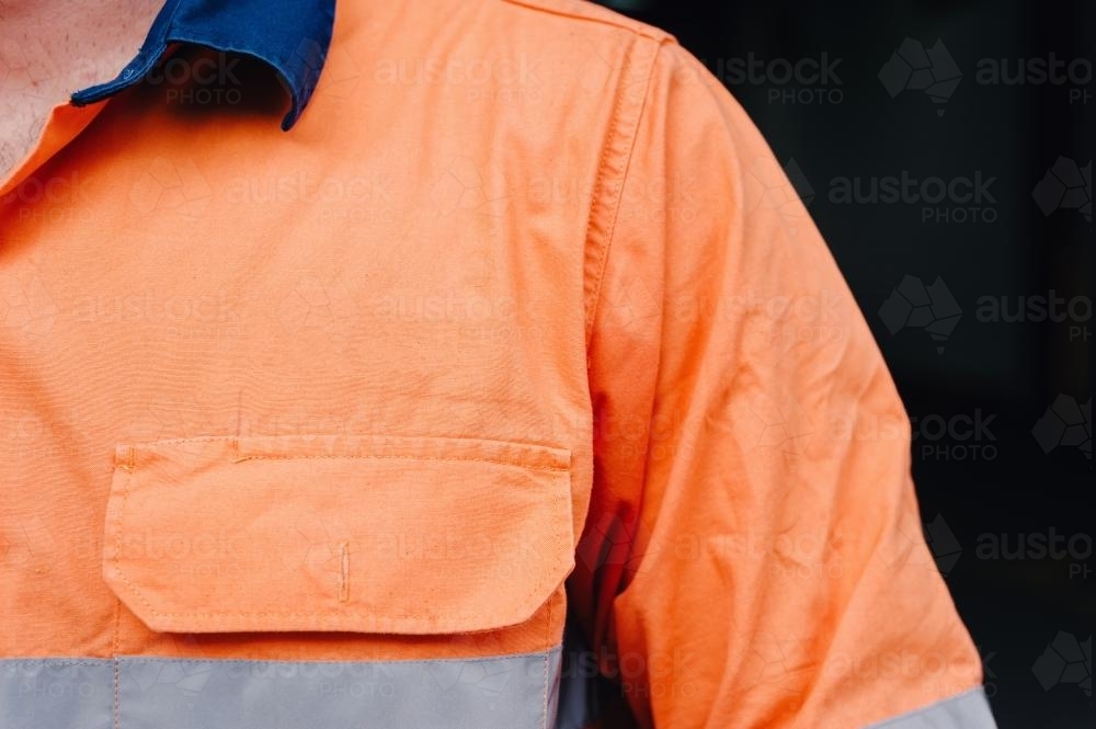 man's shoulder in hi vis workshirt with copyspace for logo - Australian Stock Image