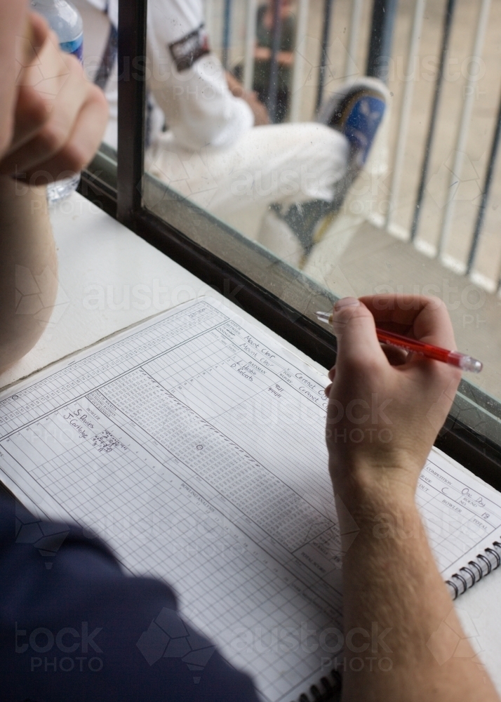 man scoring at a cricket match - Australian Stock Image