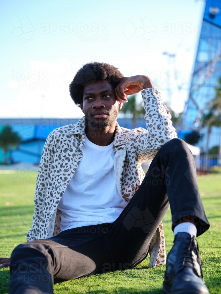 Man sitting in a park in thought - Australian Stock Image