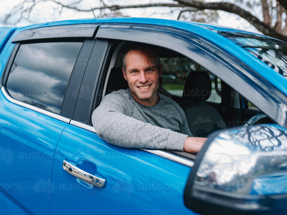 Man sitting inside blue car behind the wheel - Australian Stock Image