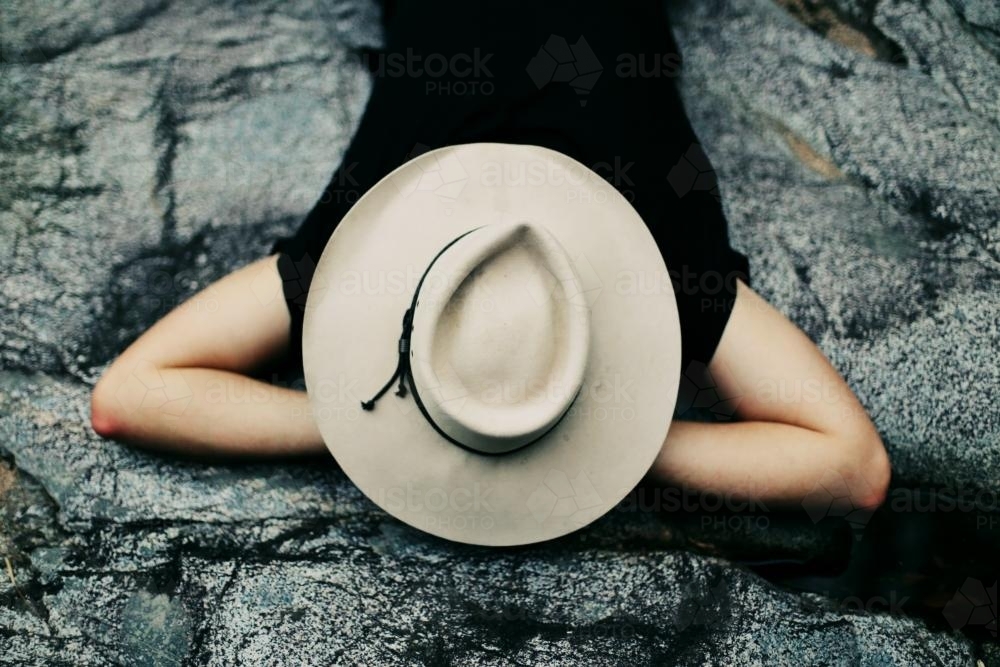 Man sleeping with hat on his face outdoors - Australian Stock Image