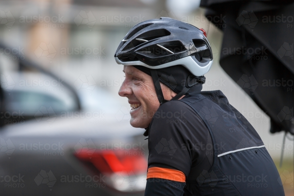 Man smiling at a cafe after a bike ride - Australian Stock Image