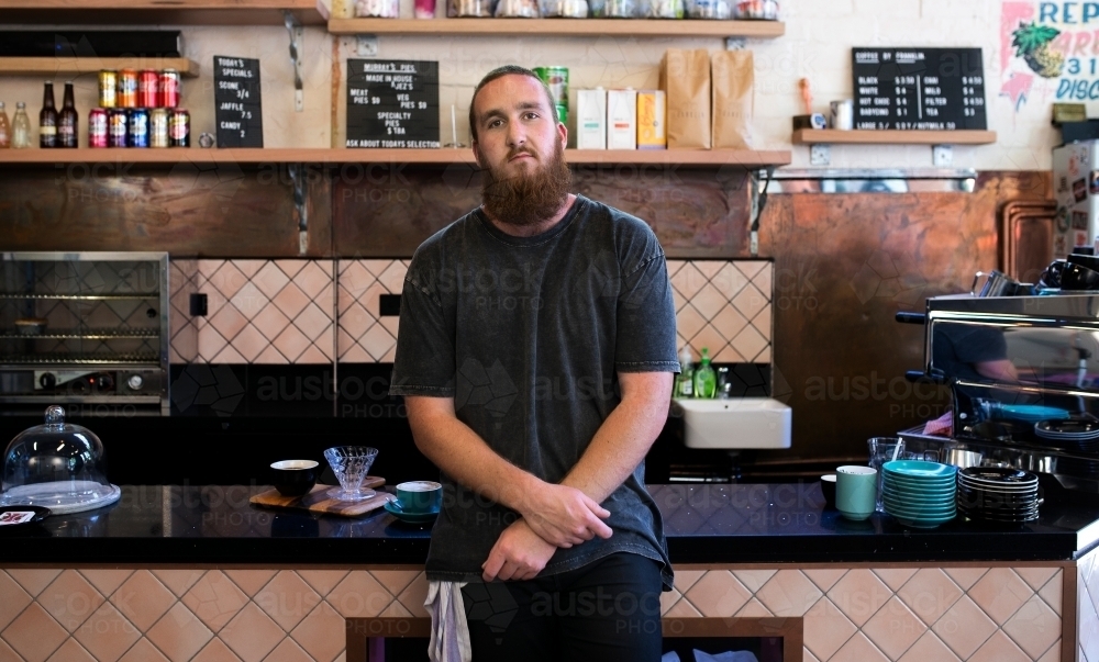 Man standing in front of cafe bench - Australian Stock Image