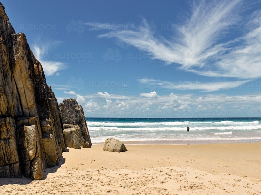 Man standing in the surf at the beach - Australian Stock Image