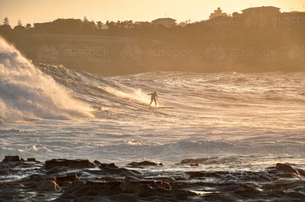 Man surfing at sunset - Australian Stock Image