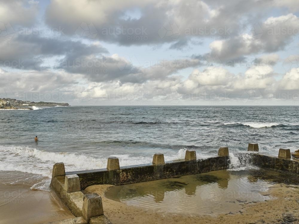 Man swimming in the sea near Coogee Ocean Pool - Australian Stock Image