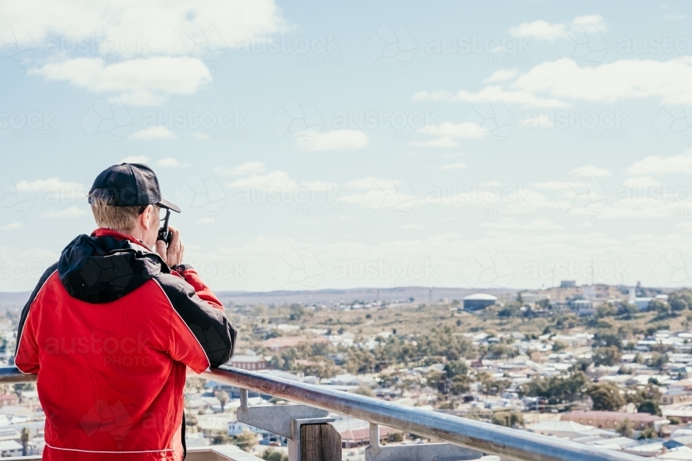 Man talking into two way radio. - Australian Stock Image