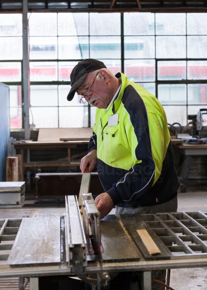 Man using a circular saw at a men's shed - Australian Stock Image