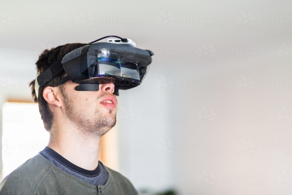 Image of Man using augmented reality technology to play a game ...