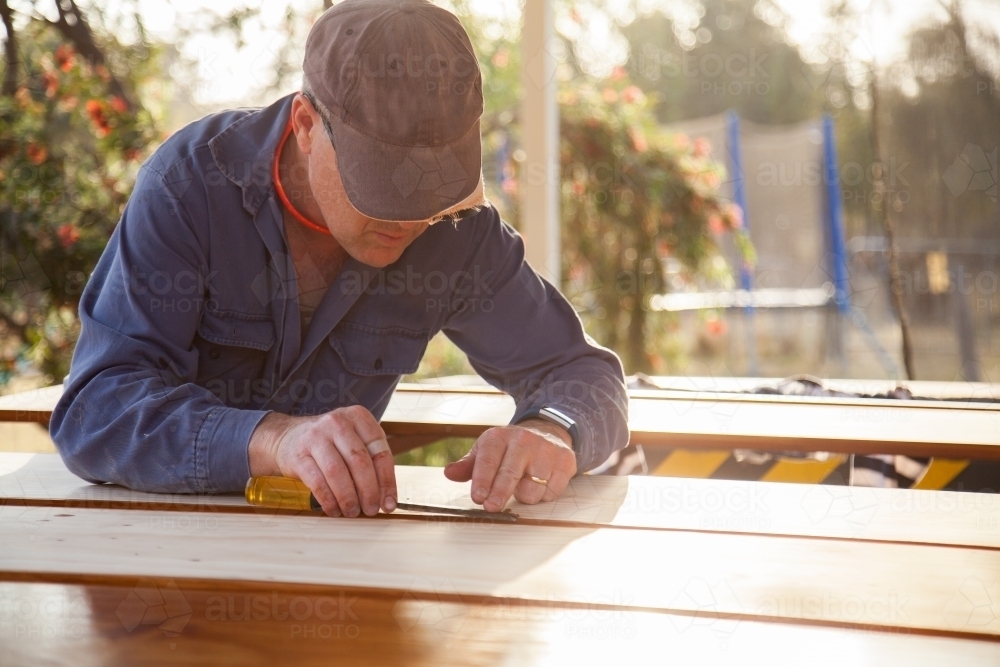 Image of Man using chisel to smooth edges of timber - Austockphoto