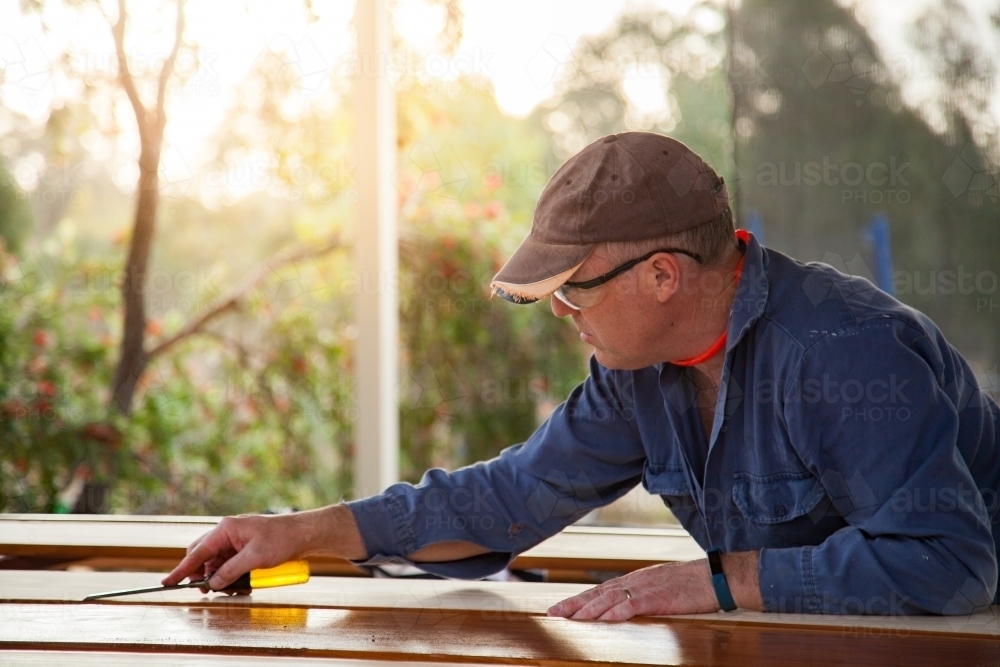 Image of Man using chisel to smooth edges of timber - Austockphoto