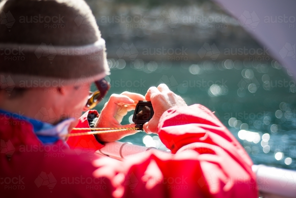 Man using GoPro video camera on boat - Australian Stock Image