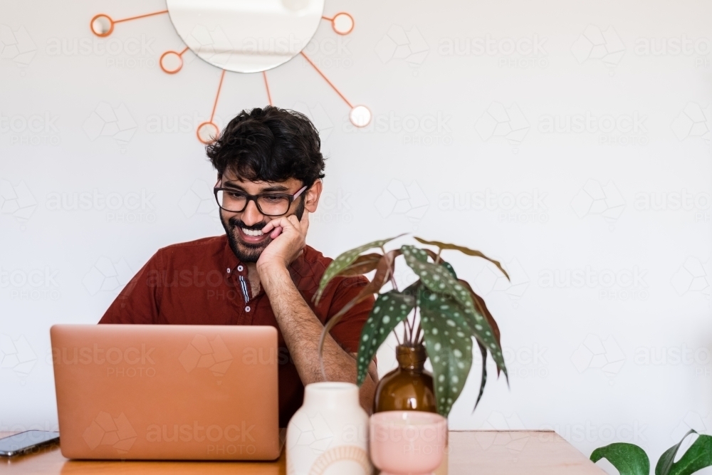 man using laptop computer at home - Australian Stock Image