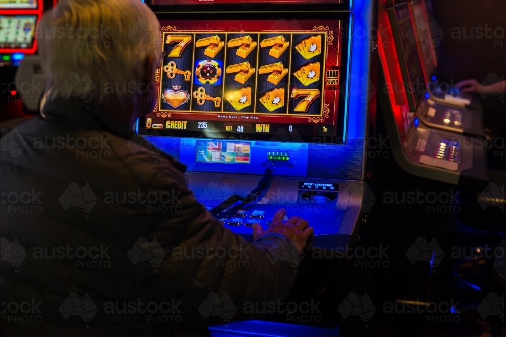 man using slot machine - Australian Stock Image