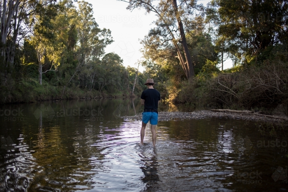 Image of Man wading through water Austockphoto