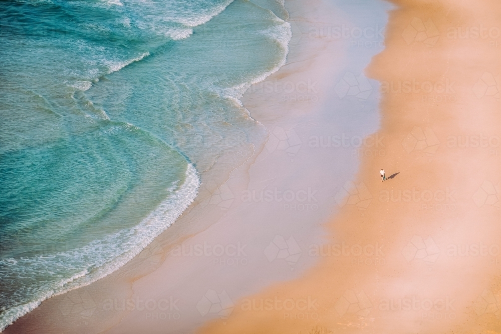 Man walking a deserted beach - Australian Stock Image