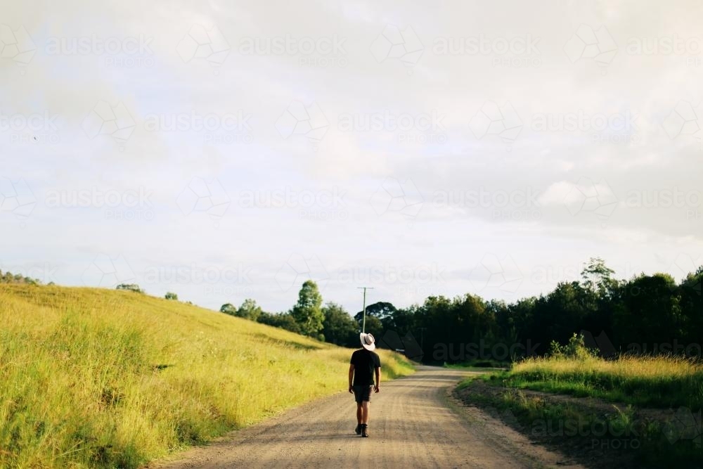 Man walking down dirt road - Australian Stock Image