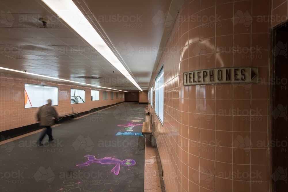 Man walking through underground train station - Australian Stock Image
