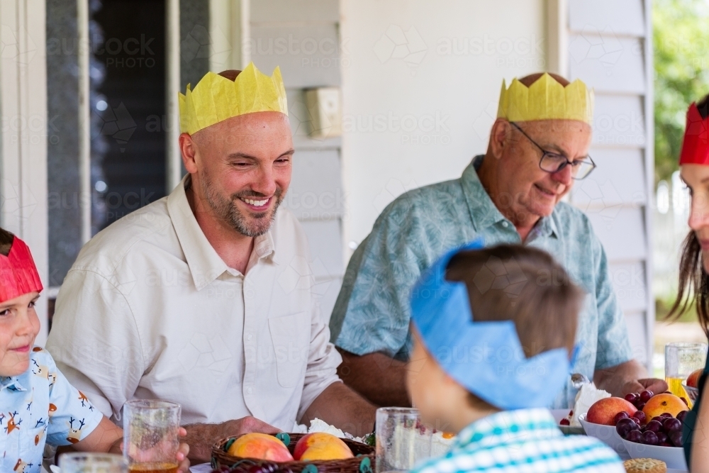 man wearing paper hat at Christmas family celebration - Australian Stock Image