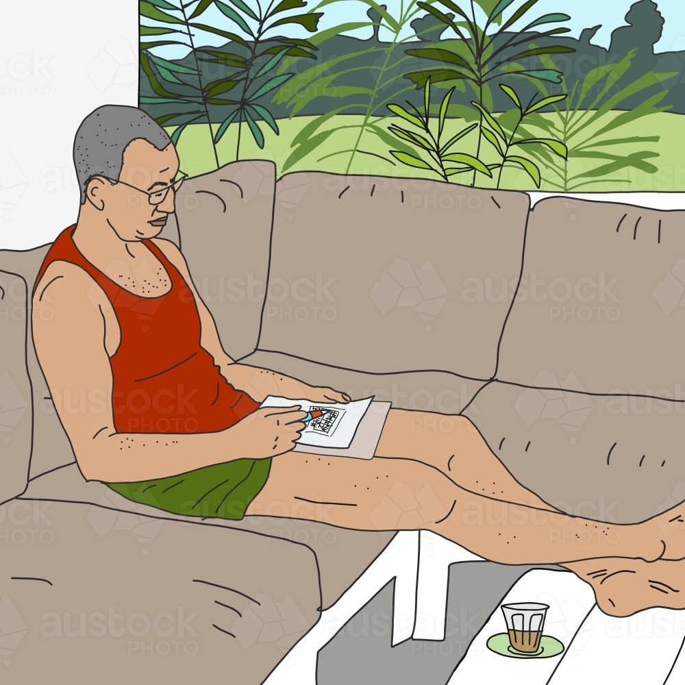 Man with bare feet sitting on balcony completing weekend puzzle - Australian Stock Image